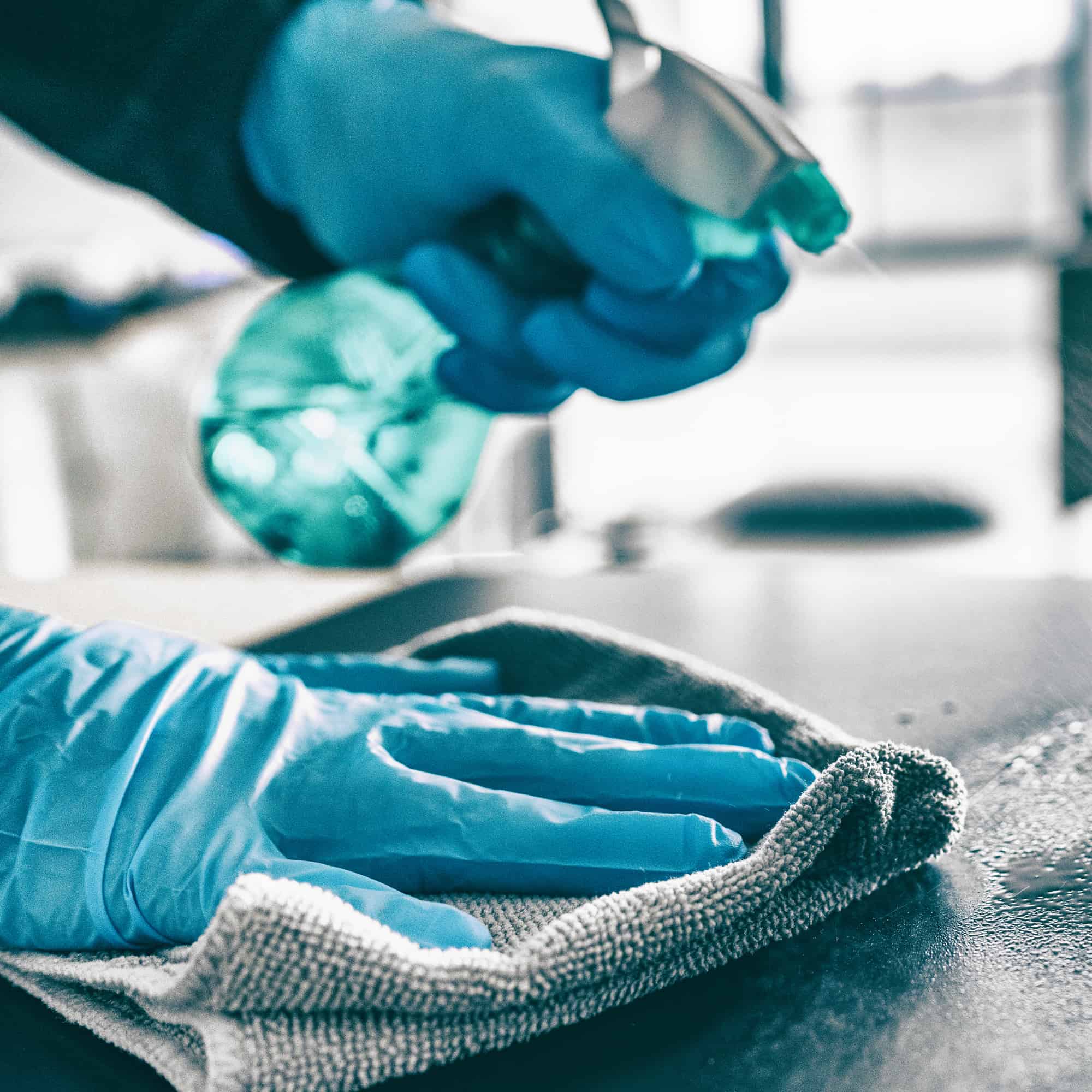 Hands with gloves cleaning table